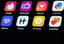 Dating app icons including Tinder, OkCupid, Hinge and Bumble on a smartphone screen.