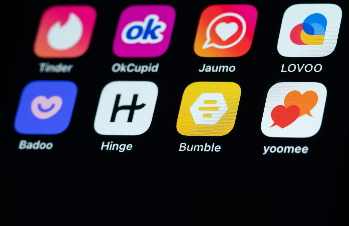 Dating app icons including Tinder, OkCupid, Hinge and Bumble on a smartphone screen.