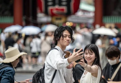 Two young adults taking a selfie outside a temple in Tokyo.